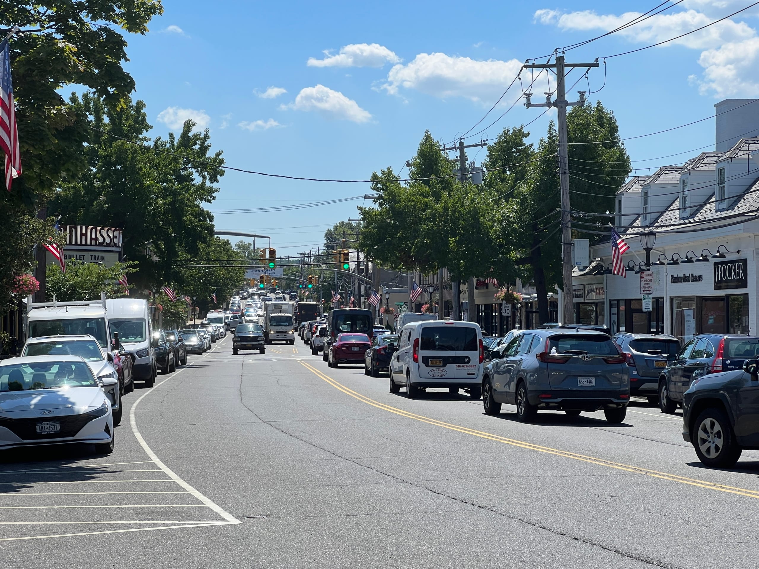 长岛 Manhasset Plandome Road 街景实拍，Wikimedia Commons 公共领域照片，可作为商业街、居住半径和 mixed-use 物业判断的视觉参照。