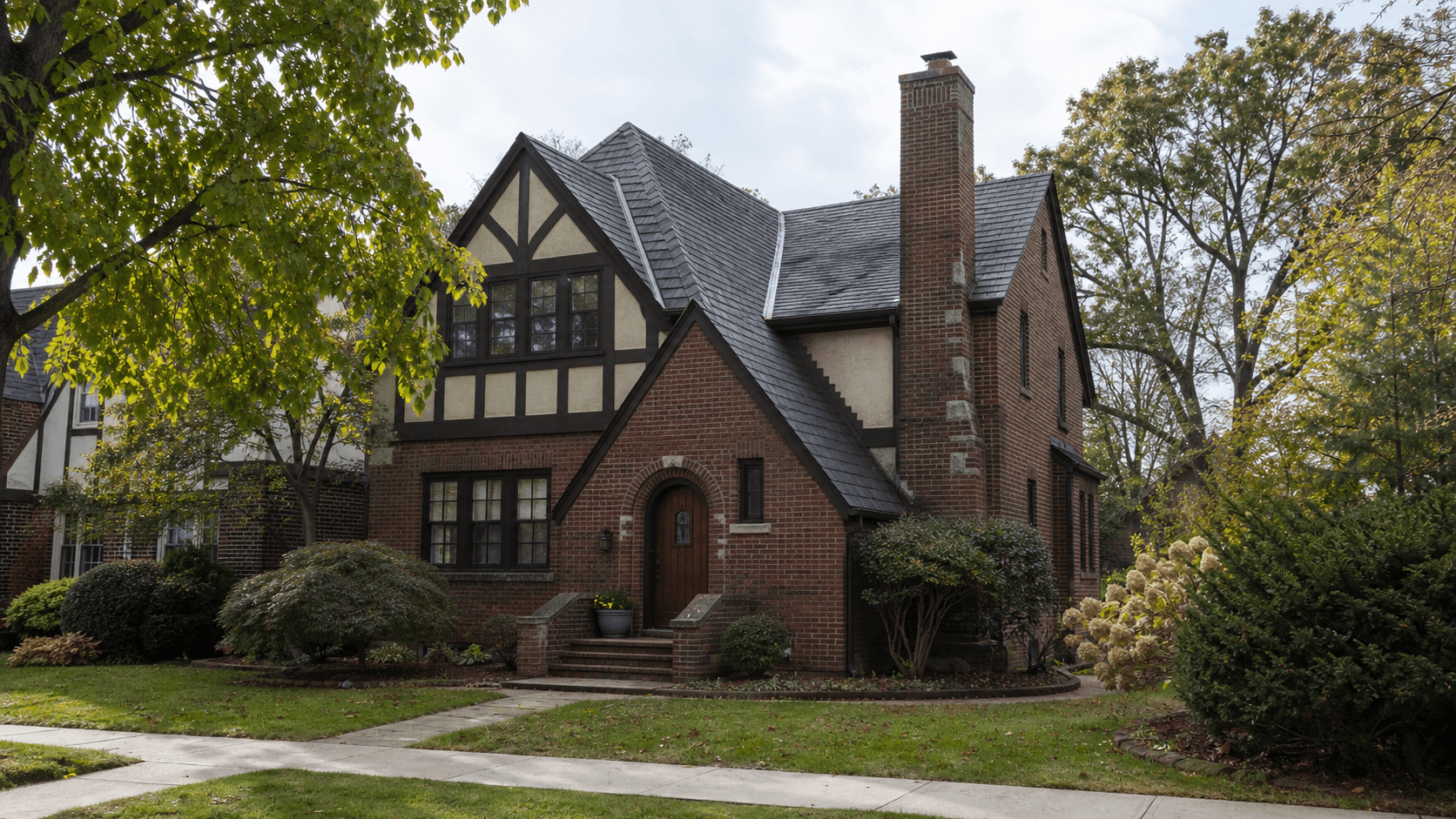 皇后区和长岛住宅街区常见的砖墙、陡屋顶和前置烟囱 Tudor Revival 房屋示意图