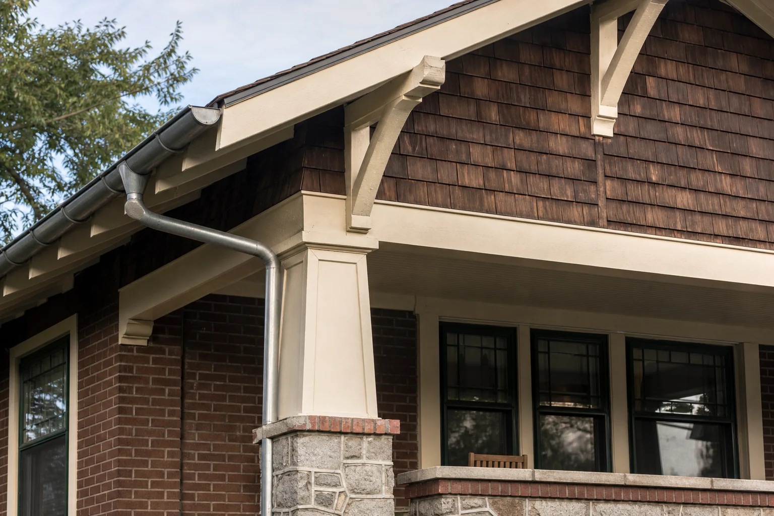 Craftsman Bungalow屋檐、外露支撑、木瓦墙面、门廊柱和砖石基座的建筑细节