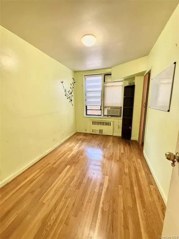 Second bedroom with window and hardwood flooring