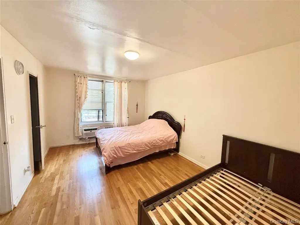 Bedroom with hardwood floor and natural light