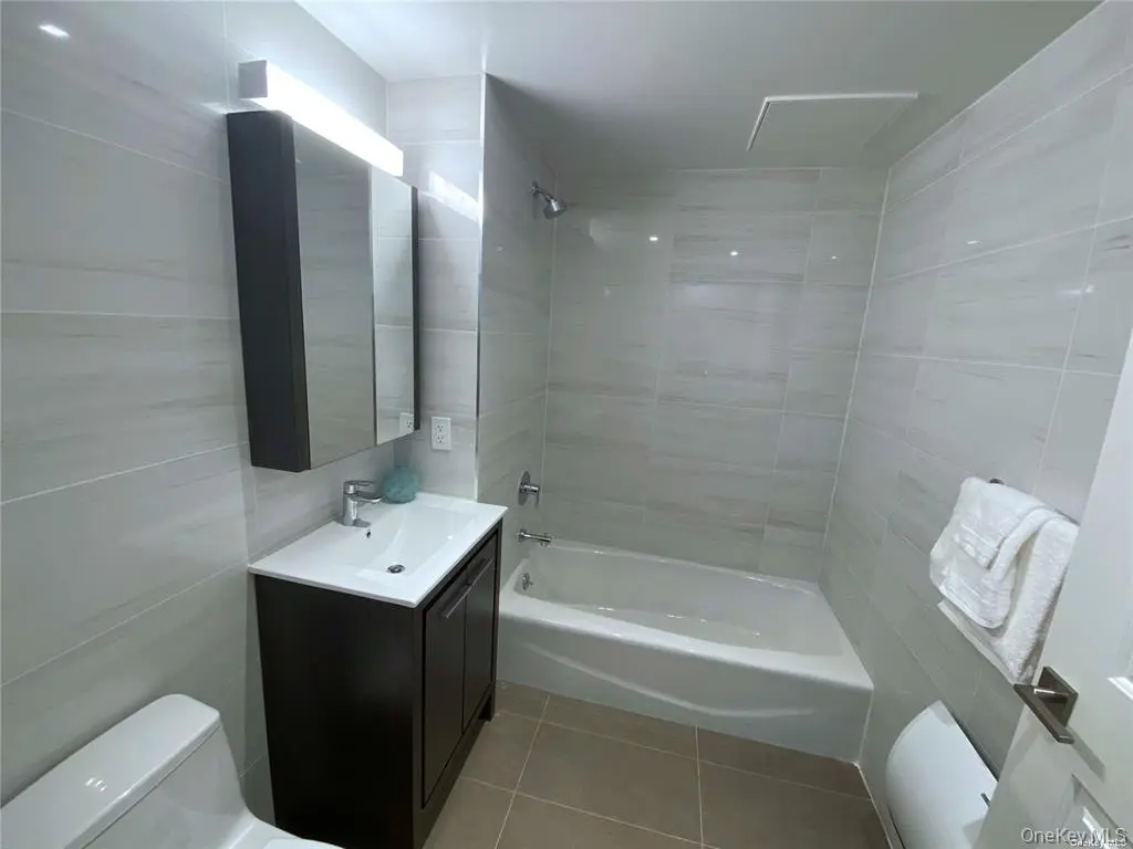 Full bathroom with tub and dark vanity