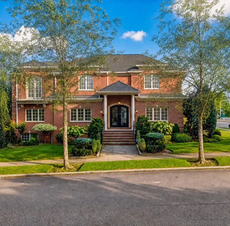 Brick house front exterior with landscaped lawn