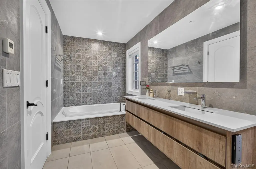 Bathroom with double vanity and bathtub