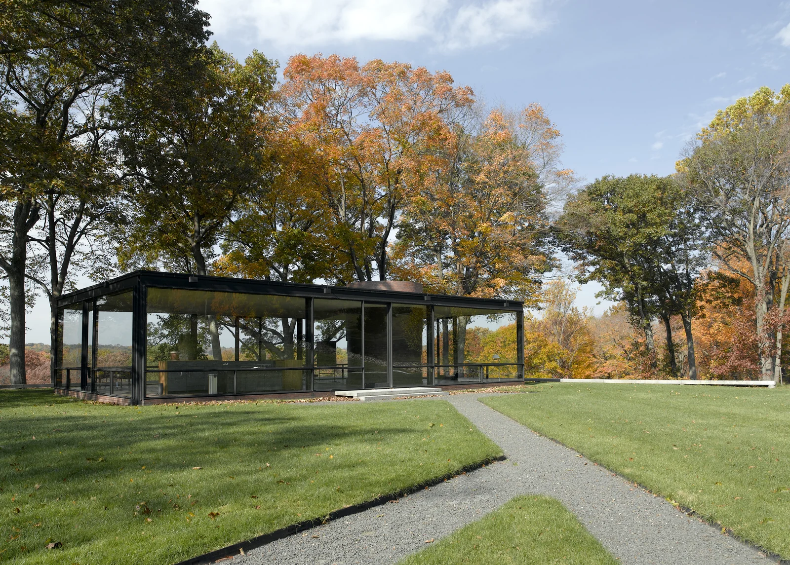 康州New Canaan的Glass House，平直屋顶和通透玻璃墙面对草坪与秋日树林