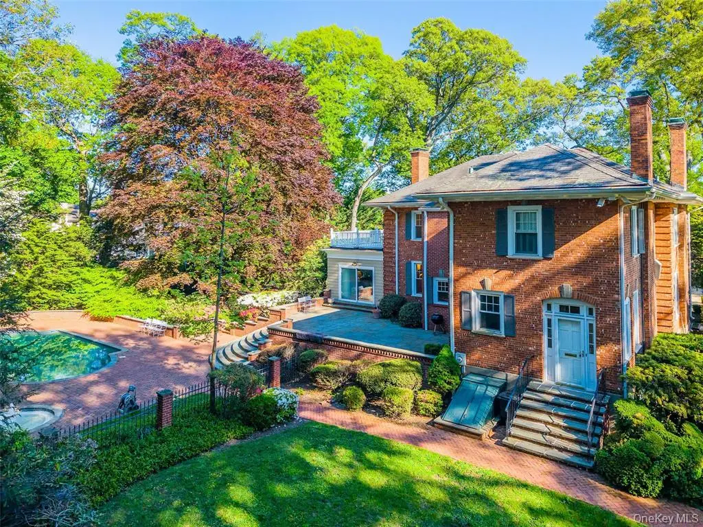 Front exterior of the brick Colonial home with landscaped entry
