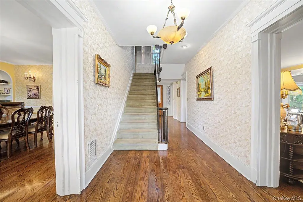 Main entry hall with hardwood flooring and staircase