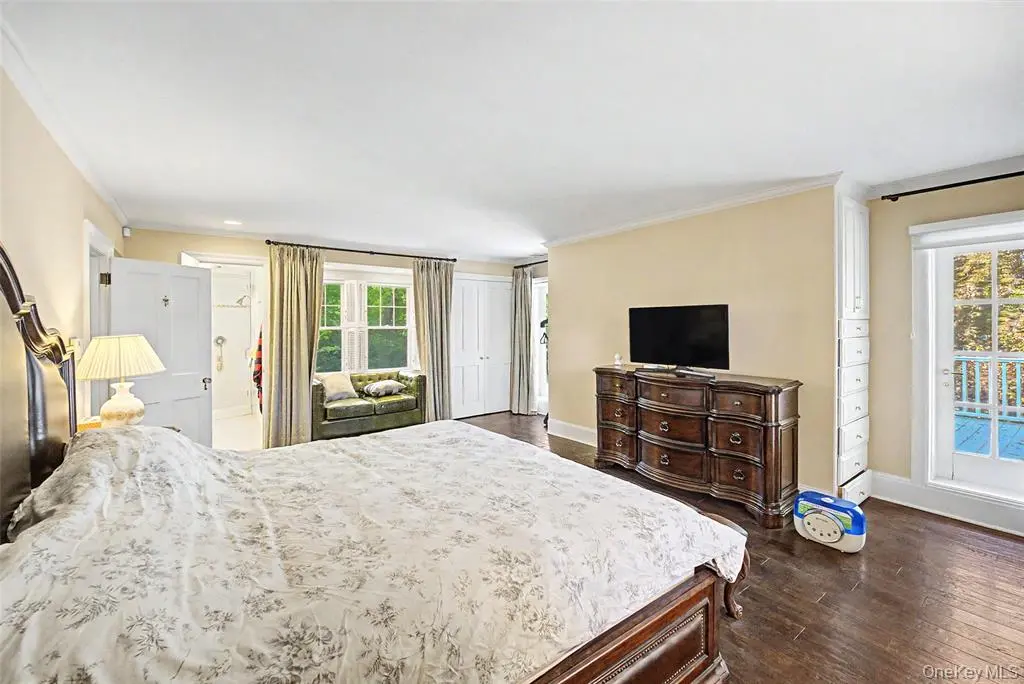 Spacious bedroom with hardwood flooring and natural light