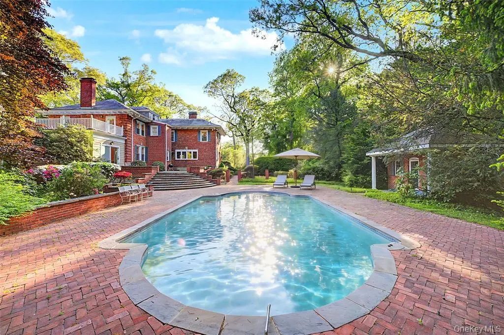 Pool terrace behind the brick Colonial residence
