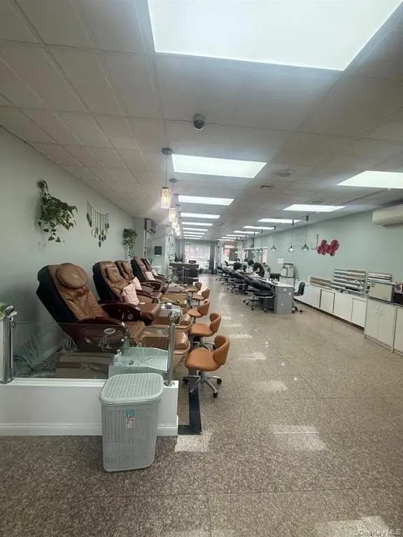 Nail salon interior with pedicure chairs and workstations
