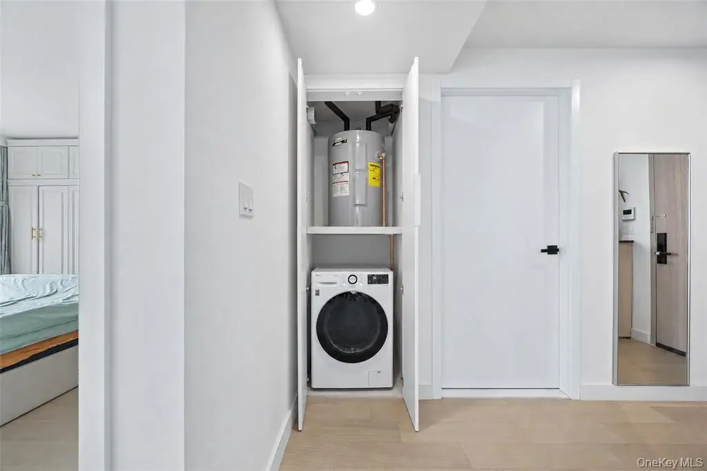 In-unit washer and dryer beside the bedroom hallway