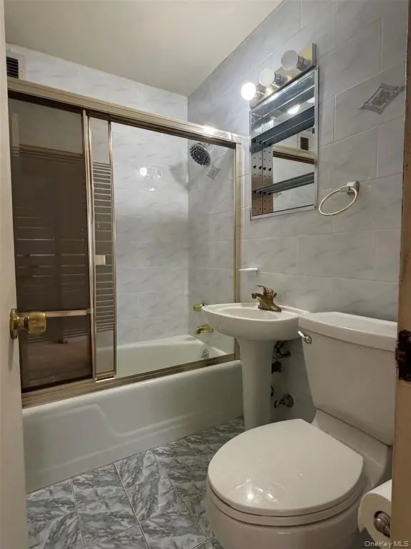 Full bathroom with tub and tiled walls