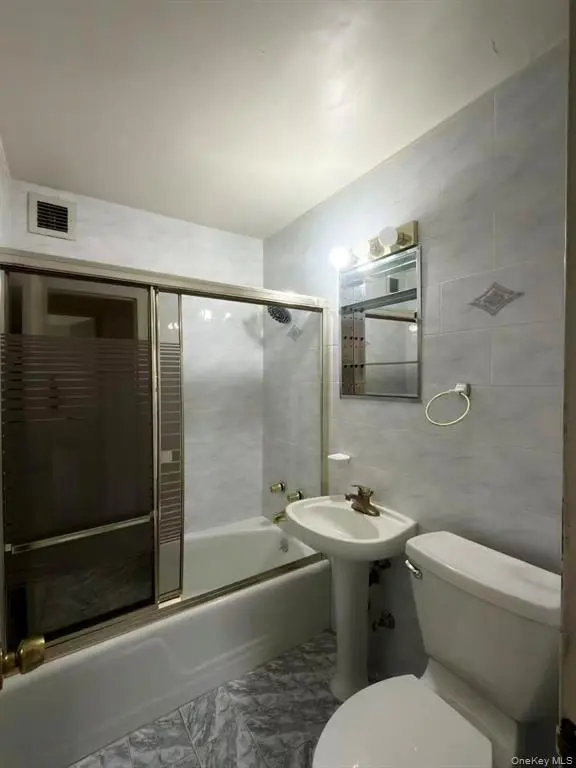 Full bathroom with tub and tiled walls