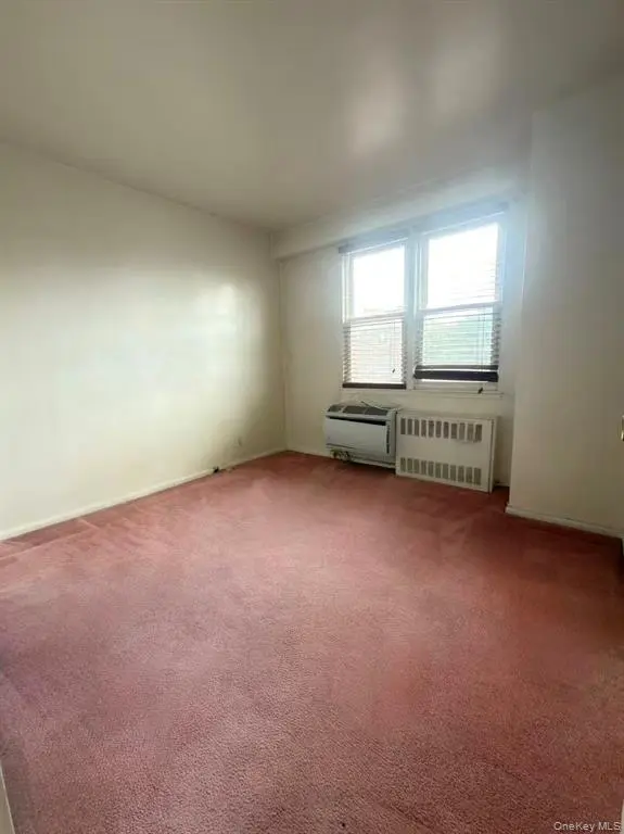 Bedroom with window and wall-mounted air conditioner