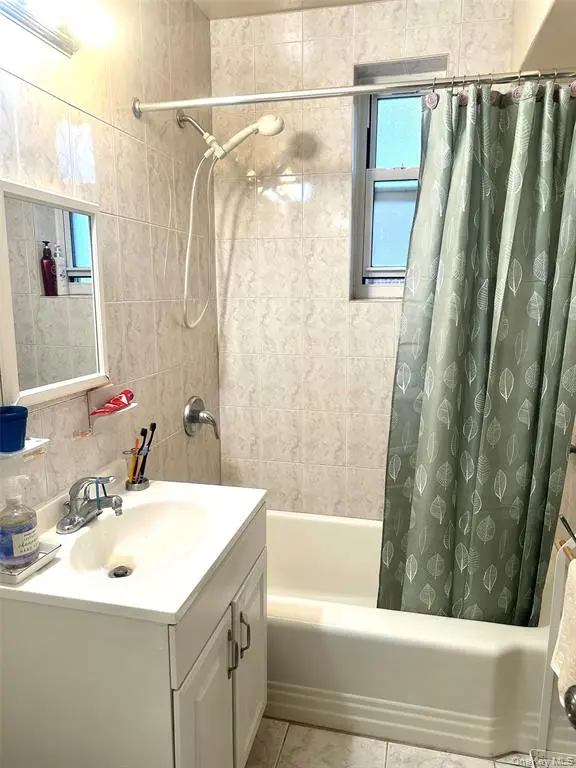 Windowed bathroom with tub and tiled shower surround