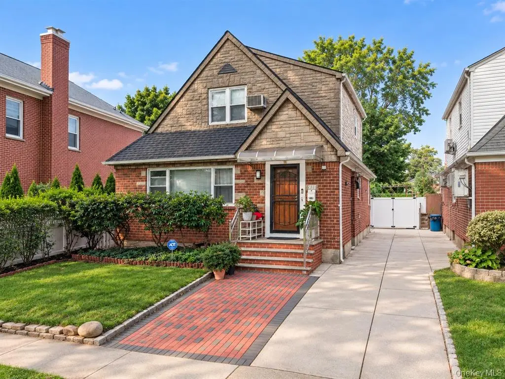 Closer front view of the brick home and landscaped entry