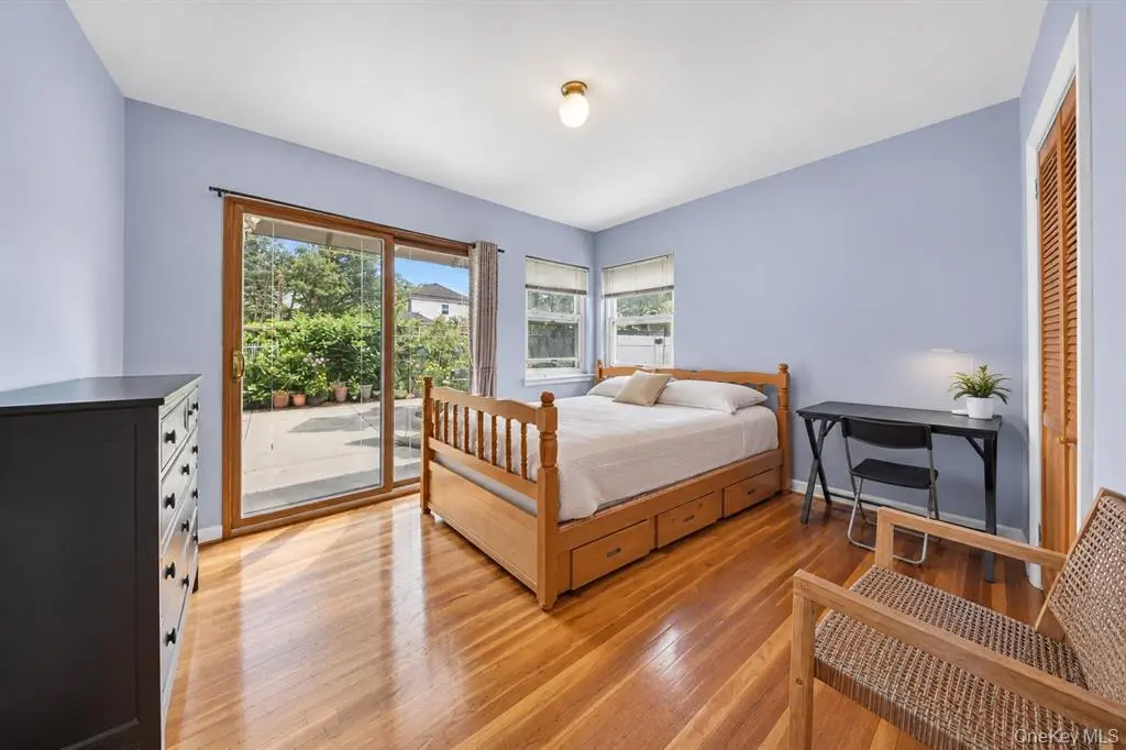 Bedroom with hardwood floor and door to outdoor space