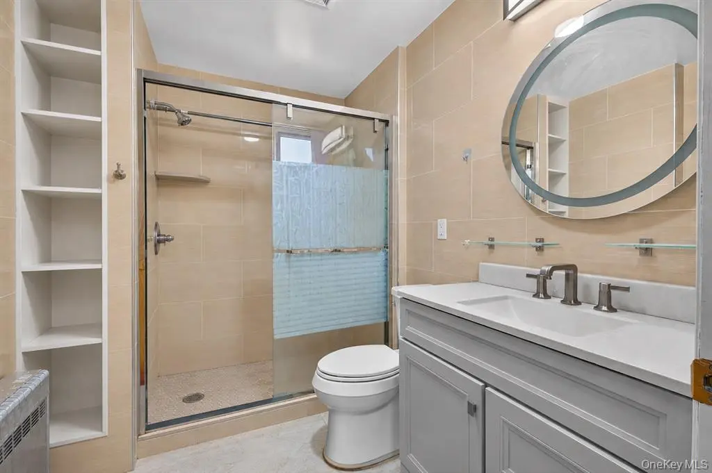 Renovated full bathroom with glass shower enclosure
