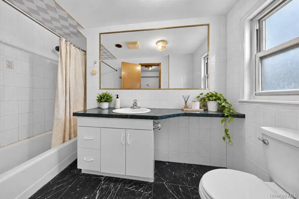 Renovated bathroom with white vanity and dark floor