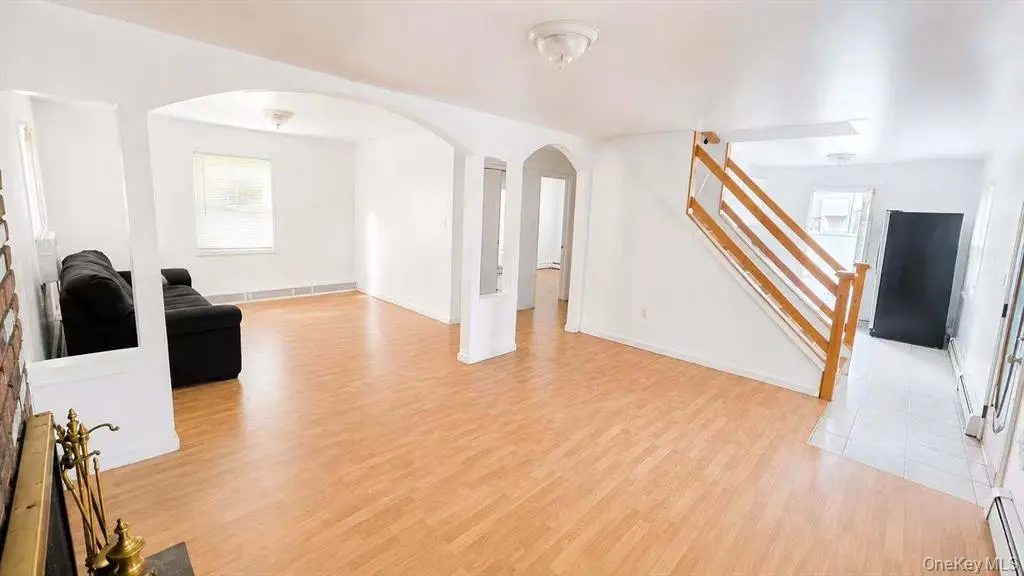 Bright living area with hardwood flooring and staircase