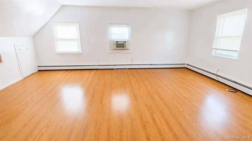 Spacious room with hardwood flooring and windows