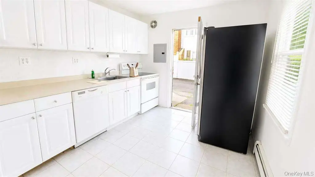 White kitchen with black refrigerator and ample cabinetry