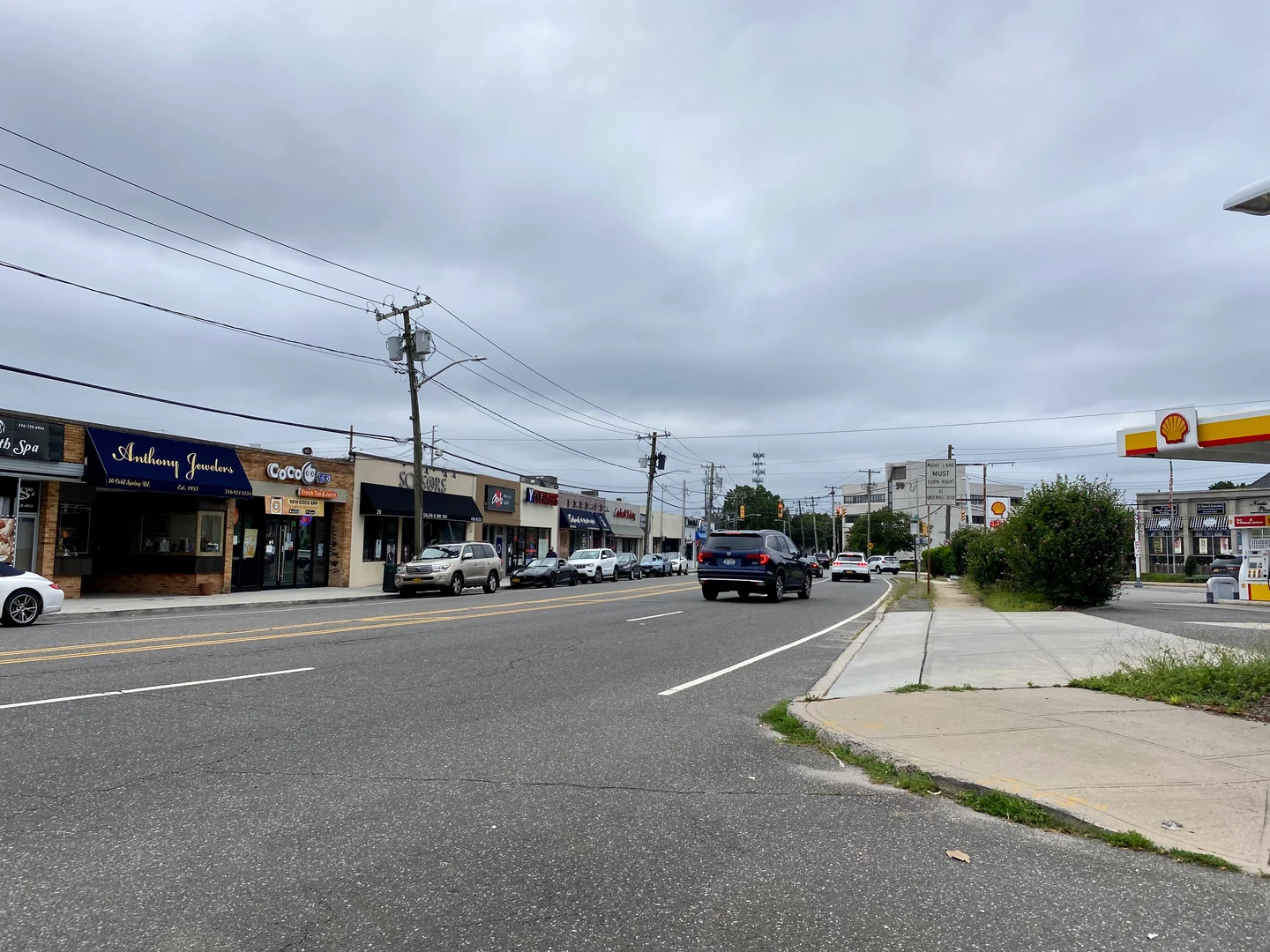 Syosset的Jackson Avenue真实街景，低矮商店、道路车辆与人行道